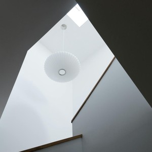 A bright, minimalist interior featuring modern lighting and architecture.